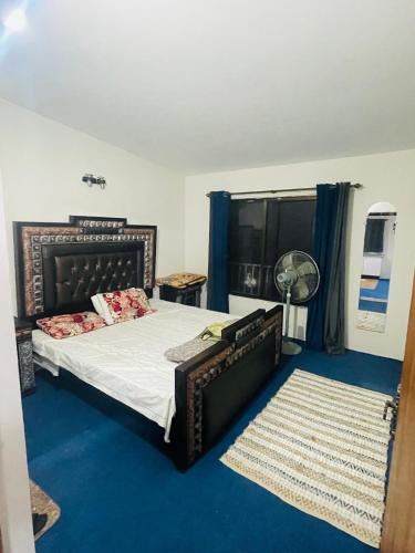 a bedroom with a bed and a blue carpet at Hillcrest Terraces Bhurban in Rāwāt