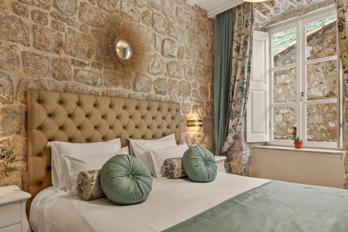 a bedroom with a bed with two pillows on it at Dominus Rooms in Dubrovnik