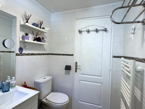 a white bathroom with a toilet and a sink at Charmant T2 à 5 minutes de l'Aéroport d'Orly in Paray-Vieille-Poste