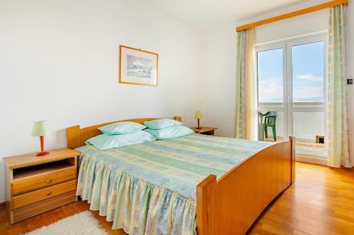 a bedroom with a large bed and a window at Villa Bunta in Sutivan
