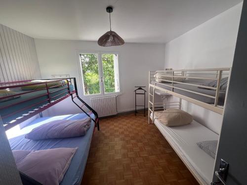 two bunk beds in a room with a window at Le Gîte de Saint Romans in Saint-Romans-lès-Melle