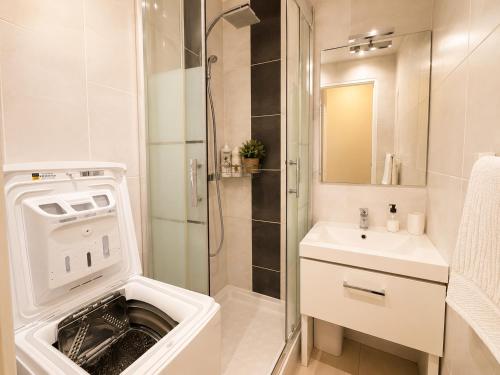 a bathroom with a sink and a washing machine at Horizon Bleu Canet in Canet-en-Roussillon