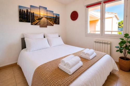 a bedroom with two towels on a bed at Horizon Bleu Canet in Canet-en-Roussillon