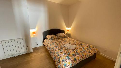 a bedroom with a bed and two pillows on it at Appartement Centre-ville Dole in Dole