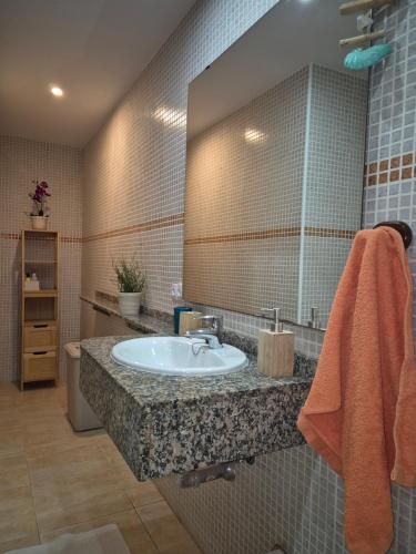 a bathroom with a sink and a mirror at Casa en Cotillo Lagos with Free Wifi & Netflix in El Cotillo