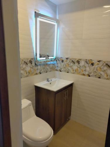 a bathroom with a toilet and a sink and a mirror at HOSPEDAJE YACUCALLE in Ibarra