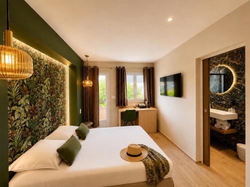 a bedroom with a large white bed and a sink at Hôtel Le Mistral in Porto-Vecchio