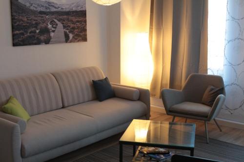 a living room with a couch and two chairs at City Apartment Leipzig in Leipzig