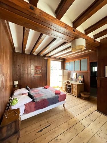 a bedroom with a bed in a room with wooden walls at La Canetterie in Dole