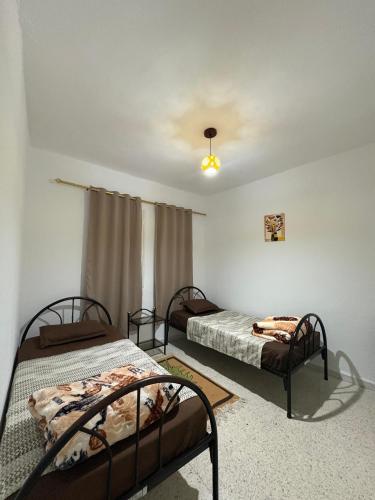 a room with two beds and a ceiling at Dar KAMOUN - 2BR Apts with 5G WiFi & Parking, Houmt Souk & Corniche in Houmt Souk