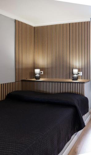 a bedroom with a black bed with two vases on it at alloggio belvedere nel borgo in Gradoli