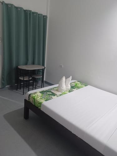 a bed in a room with a table and chairs at Sebastian Guest House in Moalboal