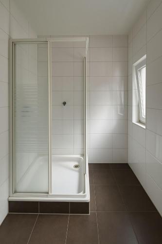 a shower with a glass door in a bathroom at ESER Hotel Pension in Beuggen