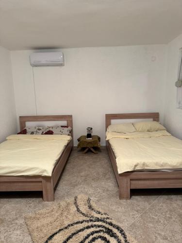 two beds sitting next to each other in a room at Apartmani Kruče in Ulcinj