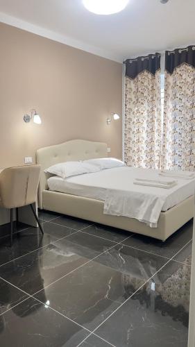 a bedroom with a bed and a chair and curtains at Hotel Solferino in Brescia