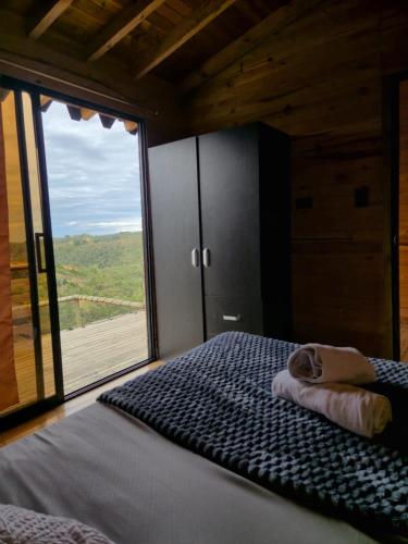 a bedroom with a bed and a large window at cabaña sol in Santa Elena