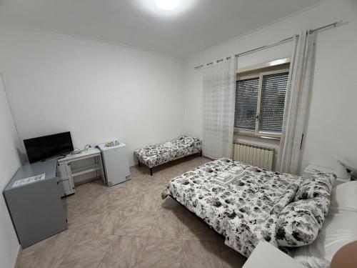 a bedroom with a bed and a tv in it at Bianca B&B in Ardea
