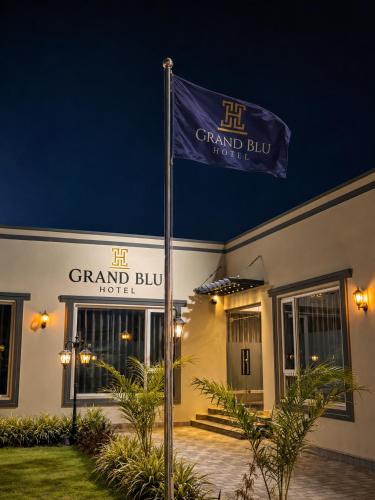a flag in front of a grand building at night at Grand Blu Hotel in Hyderabad