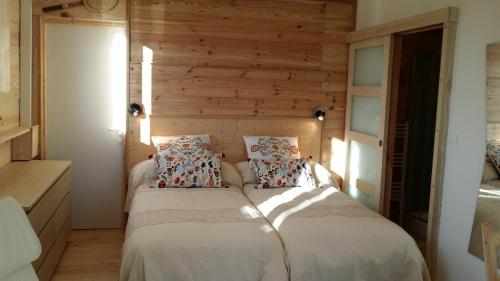 twee bedden in een kamer met houten wanden bij La Maison dans la Prairie in Bernot