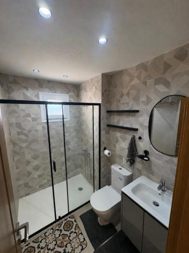 a bathroom with a shower and a toilet and a sink at New Luxury apartment with 3 pool in Cabo Negro