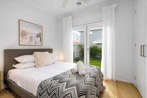 a bedroom with a bed and a large window at 3BR Light-filled Retreat Mt Duneed in Mount Duneed