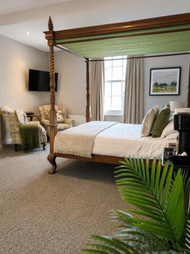 a bedroom with a canopy bed and a couch at The Raven Suites in Much Wenlock