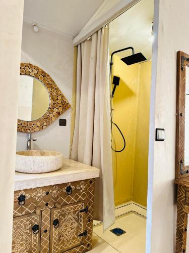 a bathroom with a sink and a shower with a mirror at Unique Luxury Camp in Merzouga