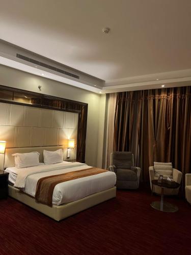 a hotel room with a large bed and a chair at فندق رفايا الشاطيء in Jazan