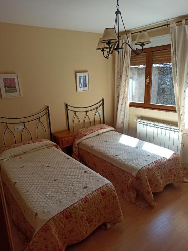 a bedroom with two beds and a window at La Ribera del Río in Trefacio
