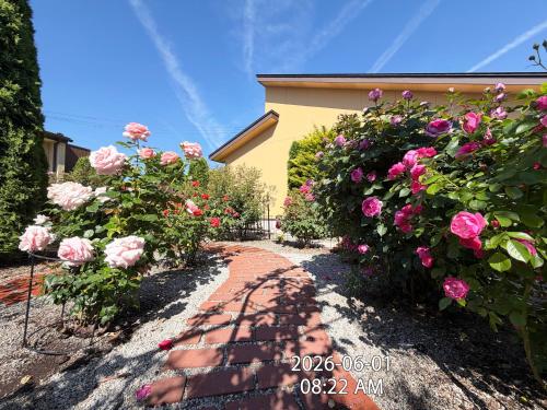 a garden with pink roses and a brick path at Hananoyado Yumefuji in Fujikawaguchiko