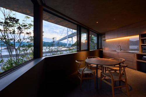 a kitchen with a table and chairs and a large window at Seaside Villa SEEN Shallow Sea in Onomichi