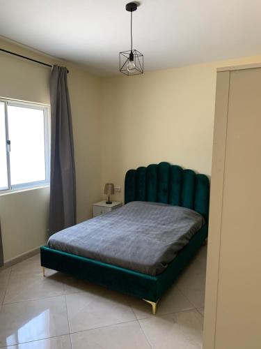 a bedroom with a green tufted bed in a room at Beautiful 2-bedroom apartment in Assomada