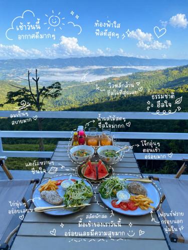 a table with plates of food on top of a mountain at Memory House ภูชี้ฟ้า เชียงราย in Ban Seng Choi