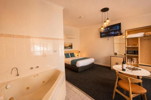 a hotel room with a bed and a bathroom at Glenelg Motel in Adelaide