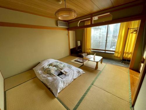 a room with a bed and a table in it at Uchihan in Nozawa Onsen
