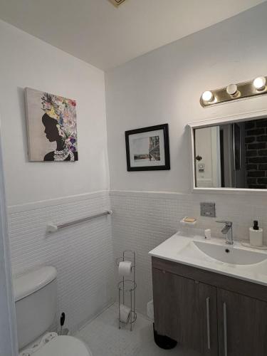 a bathroom with a sink and a toilet and a mirror at Verdun Beach, House in Montreal