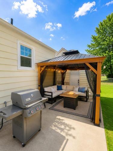 a backyard patio with a grill and a couch at Spacious Home with Fire Pit & Game Room Near Yale in Hamden