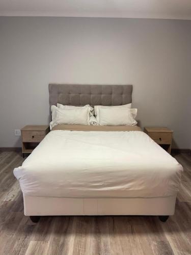 a bed with white sheets and pillows on it at Khomasdal B&B in Windhoek