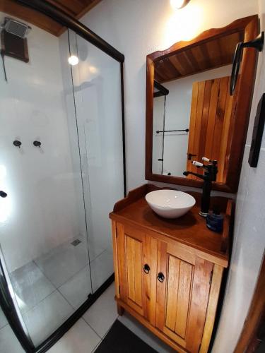 a bathroom with a sink and a shower at Chalé Terra Nova in Itamonte