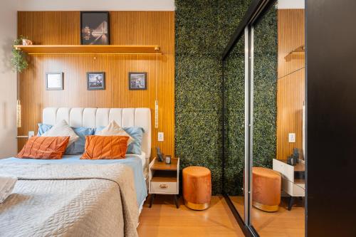 a bedroom with a bed with orange pillows on it at Hospedez - Estudios Neo São Caetano in São Caetano do Sul