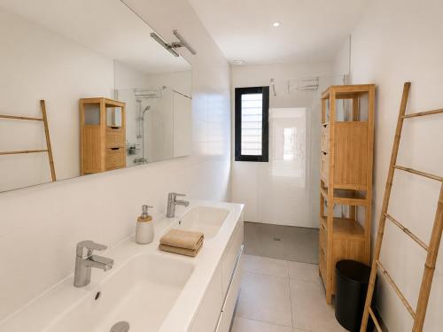 a white bathroom with a sink and a mirror at Oasis Blue Perpignan Canet in Perpignan