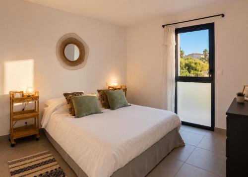 a bedroom with a large white bed with a window at Oasis Blue Perpignan Canet in Perpignan