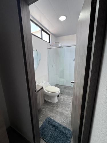 a bathroom with a toilet and a glass shower at House premium in Macanal