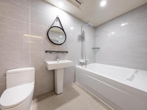 a bathroom with a sink and a toilet and a bath tub at 대구 동천 스위트 호텔 in Daegu