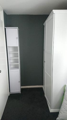 a bedroom with a white closet and a green wall at Shephall Zoo in Shephall