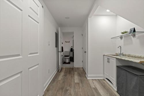 a white kitchen with white walls and wooden floors at Modern 3BR Home Patio Near Center City Free Parkin in Philadelphia