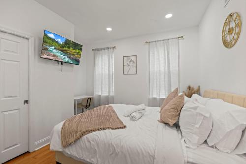 a bedroom with a bed and a tv on the wall at Modern 3BR Home Patio Near Center City Free Parkin in Philadelphia