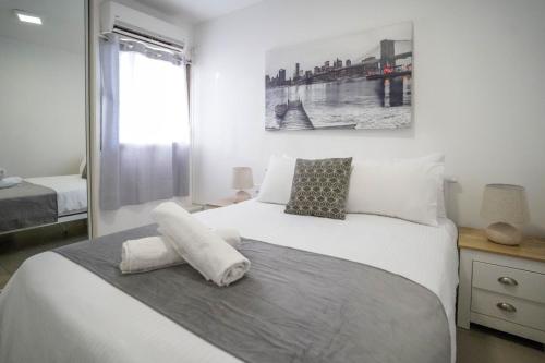 a bedroom with a large white bed and a window at Lev Eilat Suites in Eilat