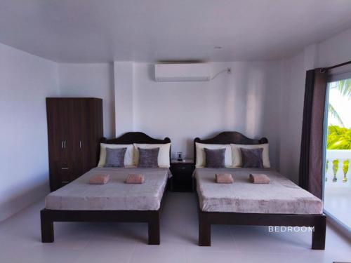 a bedroom with two beds and a window at The Clifftop Home Deluxe in Esperanza