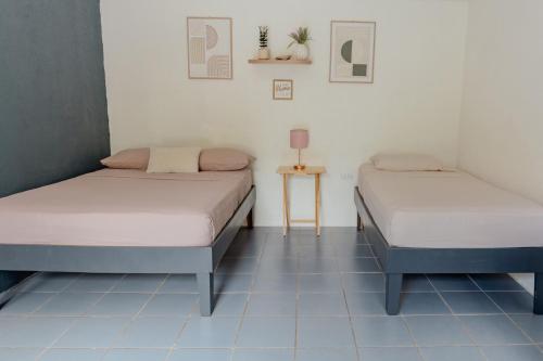 two beds in a room with blue tile floors at Rooms & Pool Macaws in Uvita